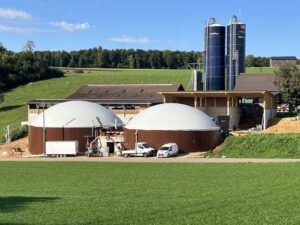 Fertige Biogasanlage mit zwei Fermentern und Silos auf einem Bauernhof – Agrigas realisiert nachhaltige Energieprojekte in der Schweiz