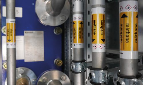 Biomethan-Rohrleitungen mit Sicherheitskennzeichnung in einer modernen Biogasanlage zur nachhaltigen Energiegewinnung.